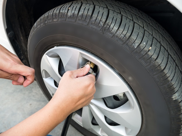 Man filling air pressure in car tyre