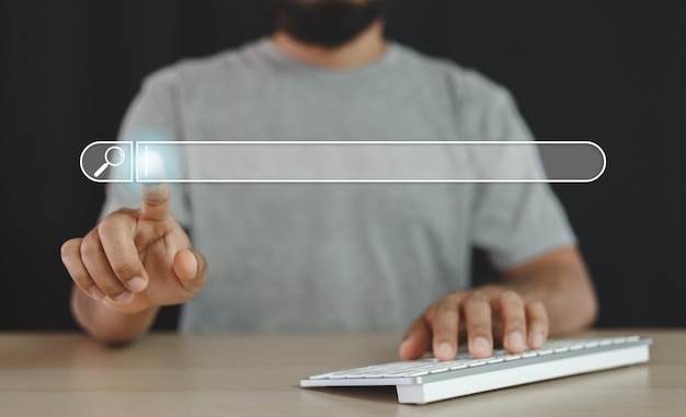 Man finger pointing at searching for information with computer keyboard. Using search website. taskbar start menu type to search bar.