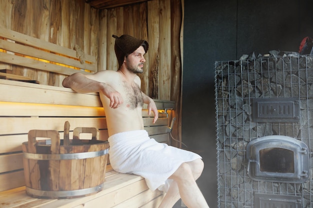 Man in finnish sauna sweating and relaxing