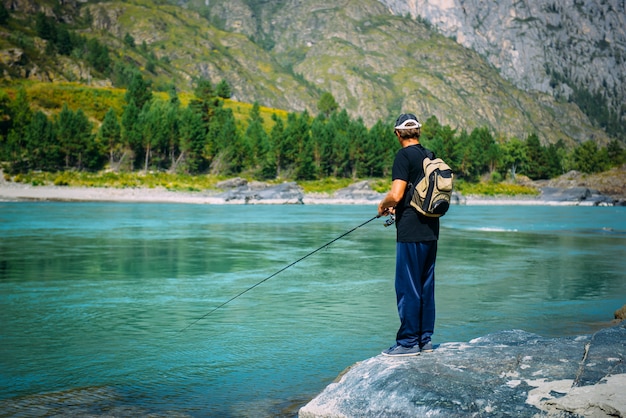 man fishing on the mountain river