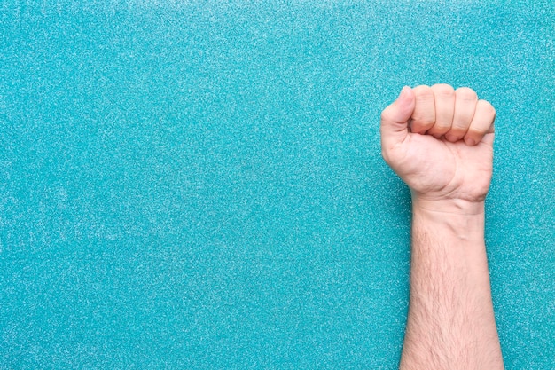 Photo man fist on pink glitter background claiming equality feminism