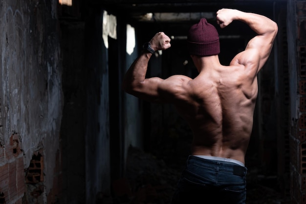 Man Flexing Back Muscles in Ruins