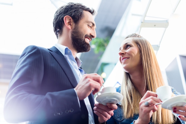 Man flirting with woman while drinking coffee