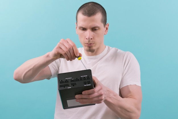 A man focused on the repair of a computer power supply with a screwdriver on a blue background Hand Workers Electronic Supply Component Connection Fixing Repairman Unit