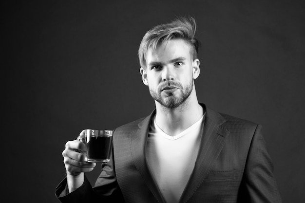 Man formal elegant suit enjoy coffee dark background Businessman elegant guy drink tea or coffee Morning coffee concept Break for relax and recharge energy caffeine beverage Have cup of coffee