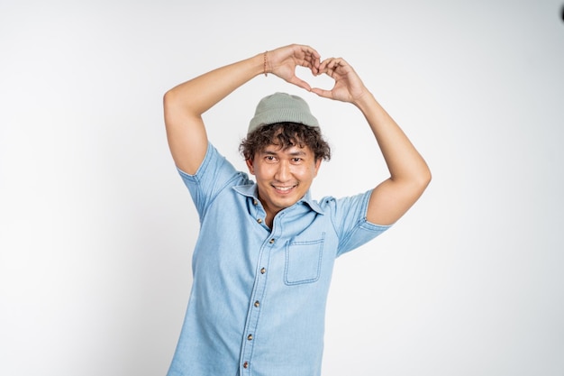 Man forming a heart with finger gestures on isolated background