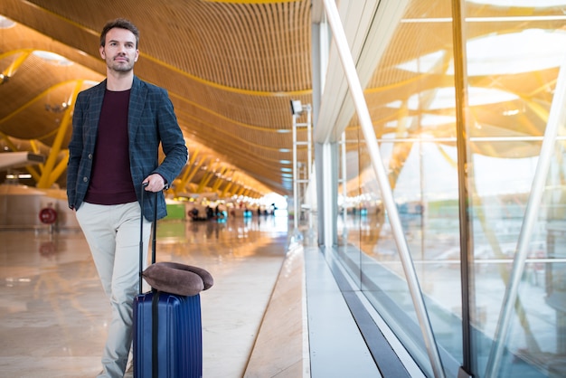 Man front walking at the airport using mobile phone