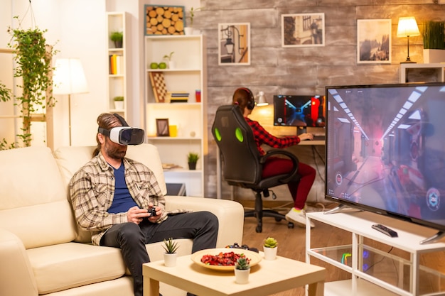 Man gamer using a VR headset to play video games in the living room late at night