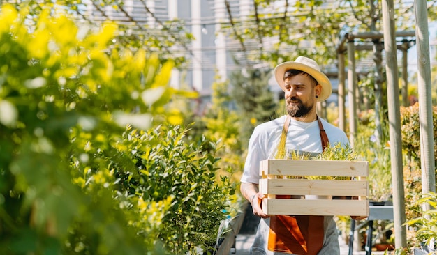 Man gardener holding a box of flowers Ecommerce online order concept