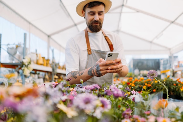 Man gardener working wit mobile phone ecommerce online order concept high quality photo