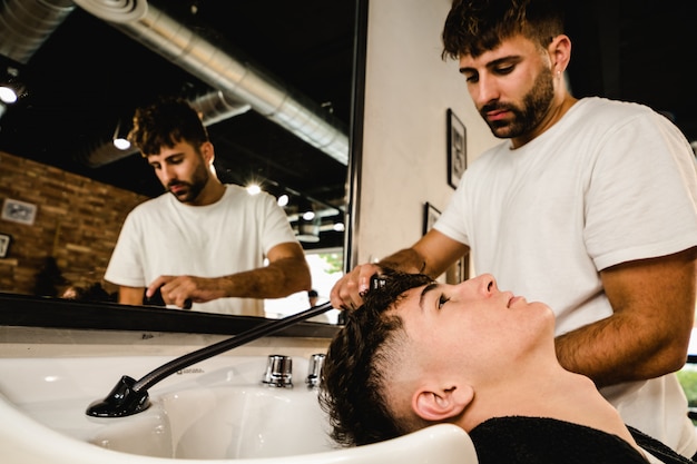 Man getting his hair washed by professional hairstylist