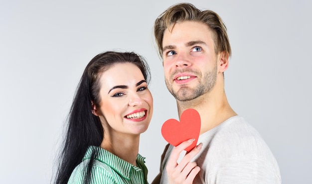 Man and girl in love. Romantic ideas celebrate valentines day. Happy together. Man and woman couple in love hold red paper heart valentines cards. Valentines day and love. Valentines day concept.