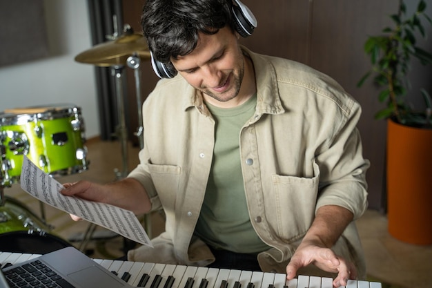 Man gives piano lesson via laptop playing notes from sheet