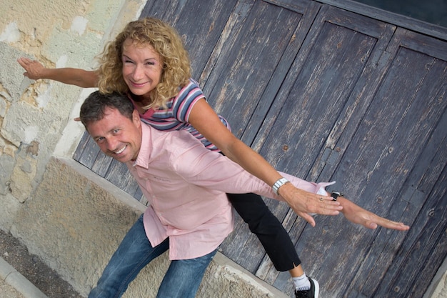 Man gives a piggyback to a woman in park