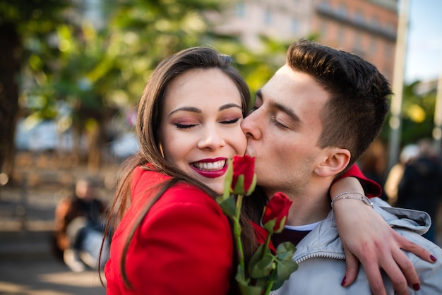 Man giving flowers and kissing his girlfriend