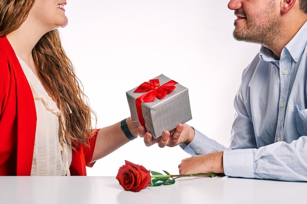 Man giving a gift and a red rose to his partner. Concept of Valentine's Day and couple in love.