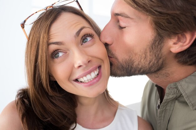 Photo man giving pretty woman kiss on the cheek