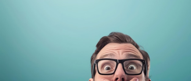 Man In Glasses Looking Up In Surprise Against A Light Blue Background