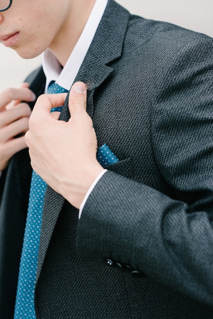 A man in a gray suit and blue tie is posing.Advertising menswear.