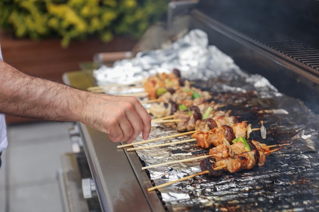 A man grilling food on a grill with food on the grill.