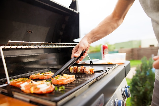 Man grilling meat and vegetables on a grill