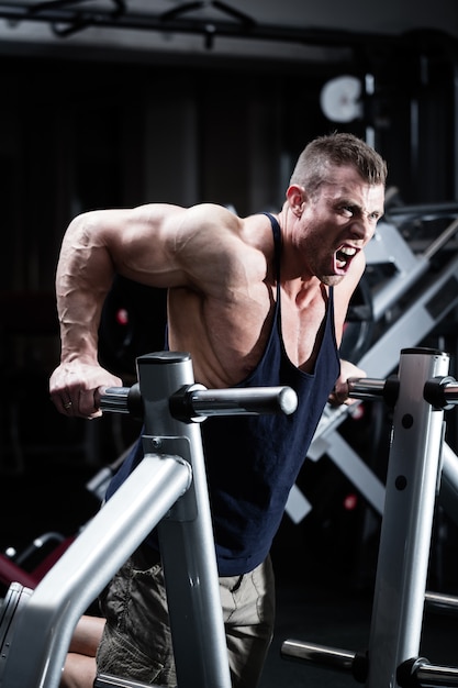 Man in gym at dip exercise