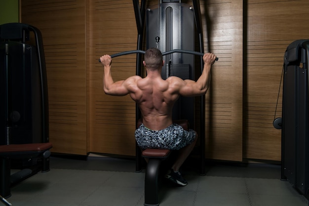 Man In The Gym Exercising Back On Machine