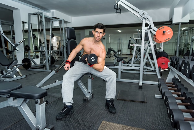 Man in gym holding dumbbell close up