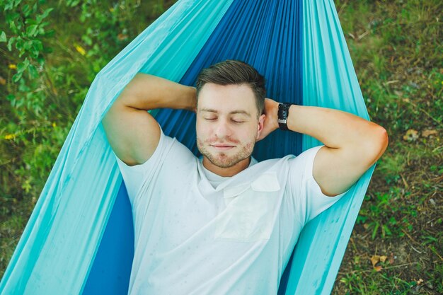 Photo a man in a hammock sits in nature and rests the concept of recreation in nature alone