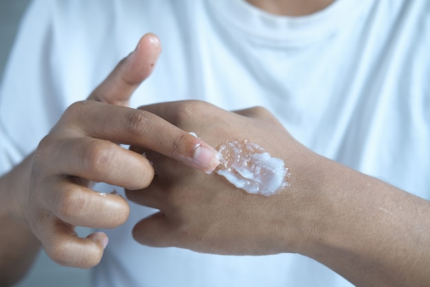 man hand applying petroleum jelly on skin