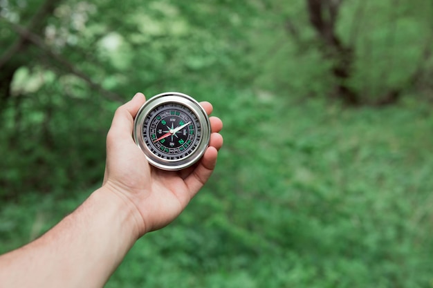 Man hand compass in forest