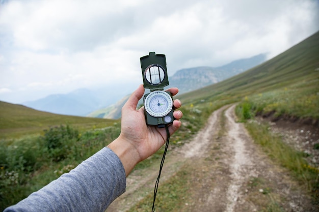 Man hand compass in mountain road