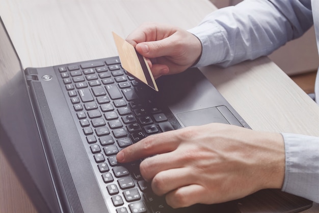 Man hand holding credit card and using laptop. Online shopping 