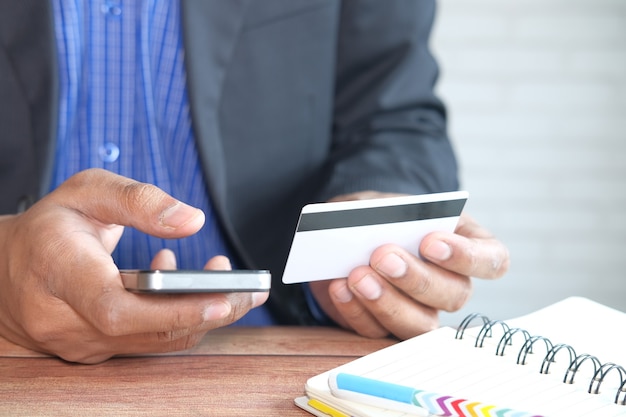 Man hand holding credit card and using smart phone shopping online