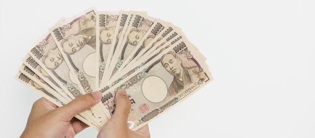 Man hand holding Japanese Yen banknote stack Thousand Yen money Japan cash Tax Recession Economy Inflation Investment finance and shopping payment concepts