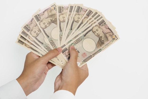 Man hand holding Japanese Yen banknote stack Thousand Yen money Japan cash Tax Recession Economy Inflation Investment finance and shopping payment concepts