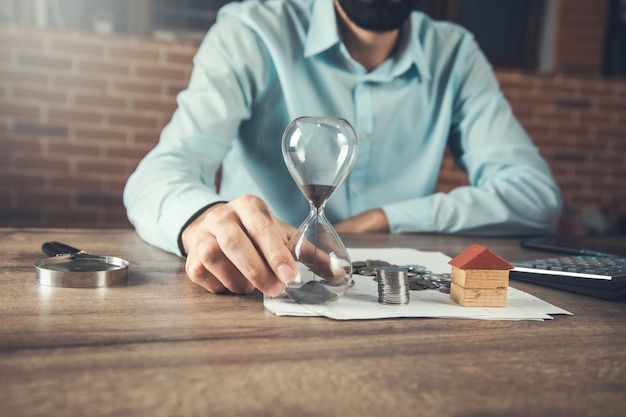 Man hand hourglass and real estate concept