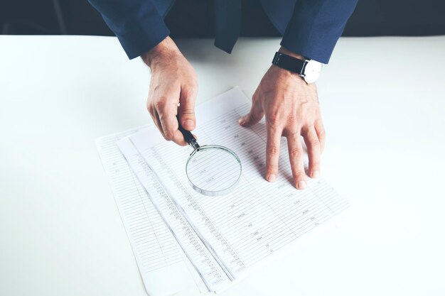 Man hand magnifier and document