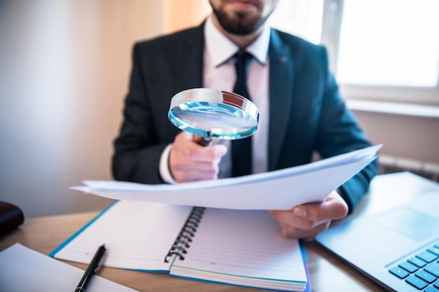 Man hand magnifier and document