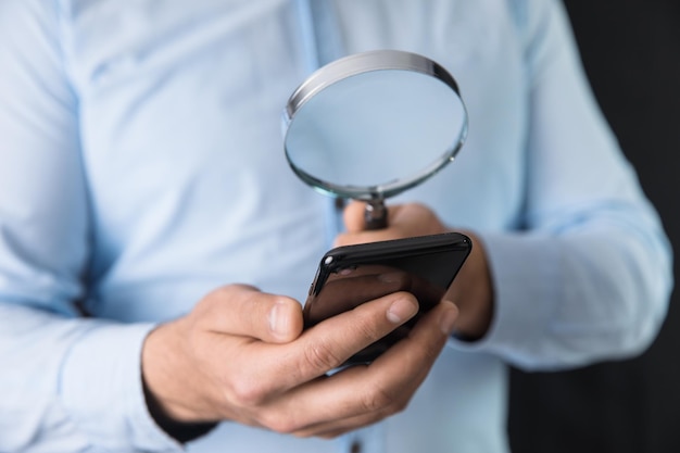 Man hand magnifier with phone