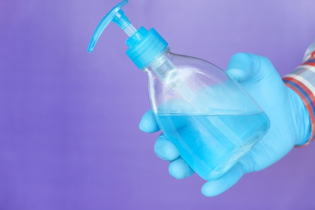 Man hand in medical gloves holding sanitizer gel for preventing virus.