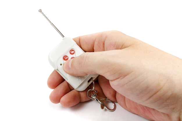 Man hand presses button on security system remote control