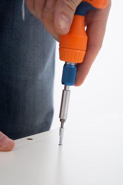 Man hand screwing the screws into furniture Assembling furniture at home