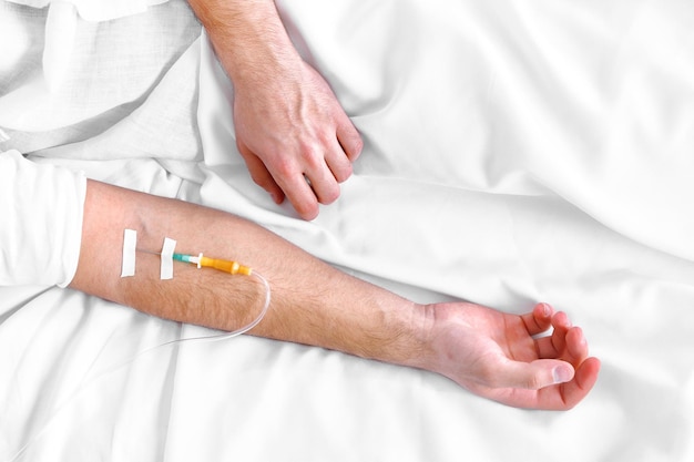 Man hand with dropper needle on bed closeup