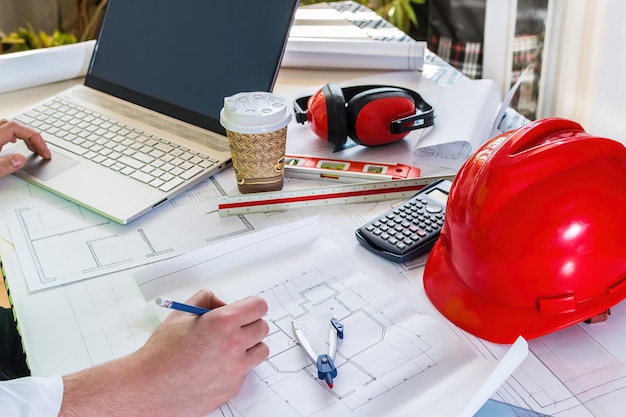 Man hand working of Architect sketching project on blueprint at site construction work