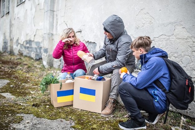 Man hands bread to a crying woman in Ukraine after accepting humanitarian aid following siege during conflict with Russia