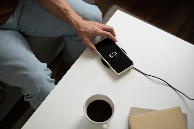 Man hands Charging mobile phone battery with low battery plugging a charger in a smart phone with energy bank powerbank charger Modern lifestyle energy technology