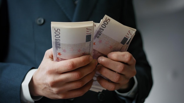 Man hands counting banknotes indoors closeup businessman calculating pack bills