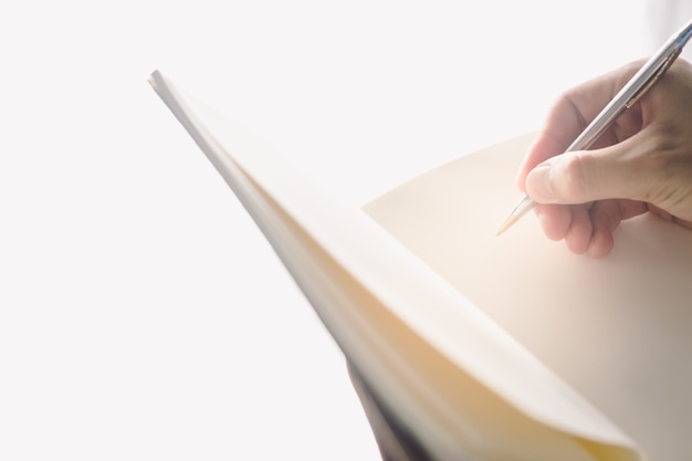 Man hands holding a book for reader with copy space at sun light background