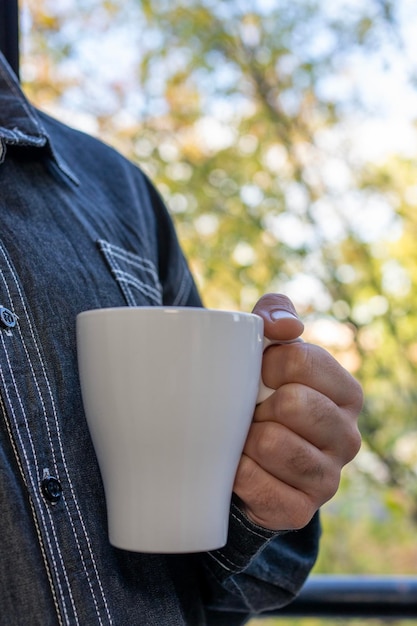 Man hands holding a coffee mug